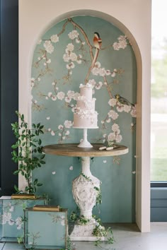 a wedding cake sitting on top of a table next to a vase with flowers in it