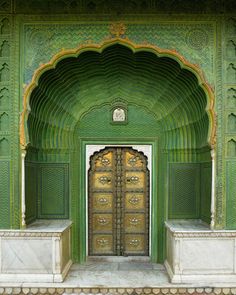 an ornate green building with gold doors