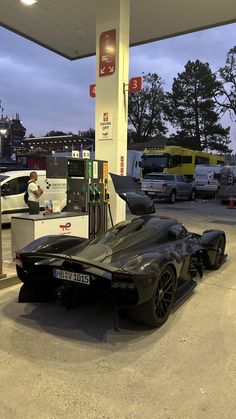 a black sports car parked at a gas station