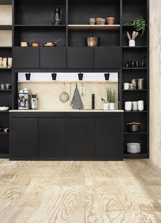 a kitchen with black cabinets and shelves filled with pots, pans and utensils