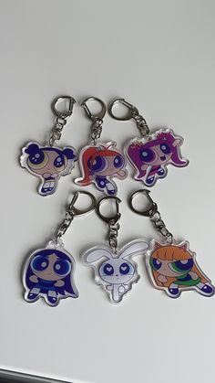 six keychains with cartoon characters on them sitting on top of a white surface