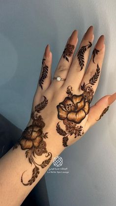 a woman's hand with hennap and flowers painted on it is shown