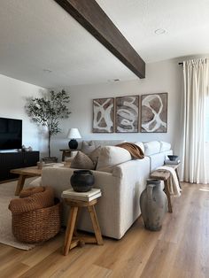 a living room filled with furniture and a flat screen tv on top of a wooden floor