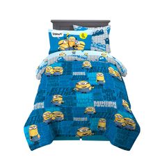 a bed with blue and yellow despicables comforters on top of it