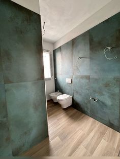 a bathroom with green walls and wood flooring