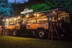 a food truck is parked in the grass at night