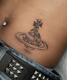 a woman's stomach with a small tattoo on her belly and an object in the middle