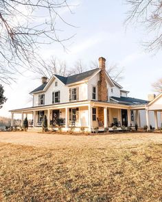 a large white house sitting on top of a grass covered field