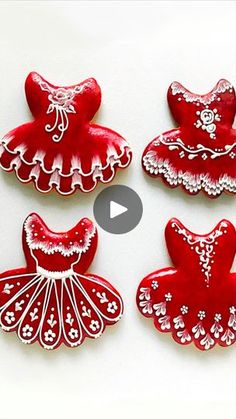 four red and white decorated cookies sitting on top of a table next to each other