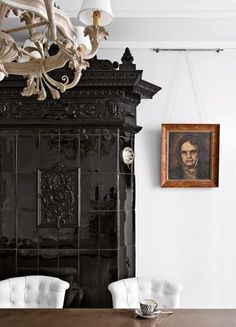 a dining room table with white chairs and a painting hanging on the wall behind it