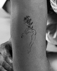 a woman with a flower tattoo on her leg is holding onto a man's arm