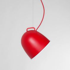 a red light hanging from the side of a white wall