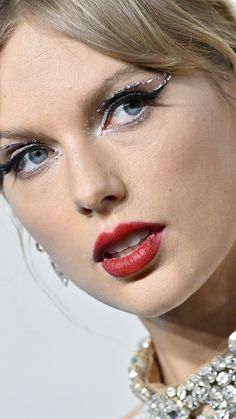 a close up of a woman with red lipstick and eyeliners on her face