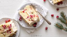 two slices of cake on paper plates with cranberries and pine branches next to them