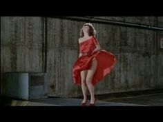 a woman in a red dress is dancing