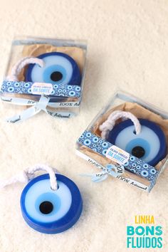 two blue glass eyeballs in a box with twine and white string tied around them