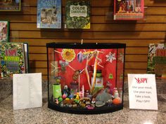 a display case filled with lots of toys and books on top of a marble counter