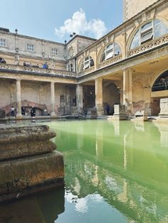 an old building with green water in the middle