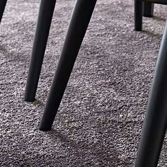 three black metal stools sitting on top of a carpeted floor next to each other