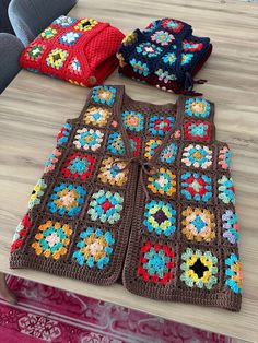 three crocheted sweaters sitting on top of a table next to each other