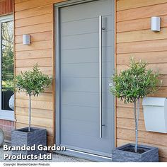 a modern front door with two planters and toilet paper dispensers