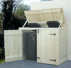 an outdoor storage shed with doors open and trash cans in the bins on the side