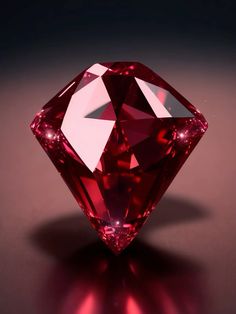 a pink diamond on a black surface with red light shining through it's center