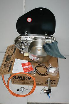 an assortment of cooking equipment sitting on top of a cardboard box with other items around it