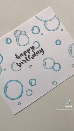 a happy birthday card with water bubbles on it and the words happy birthday written in black ink