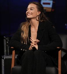 a woman sitting in a chair smiling at someone