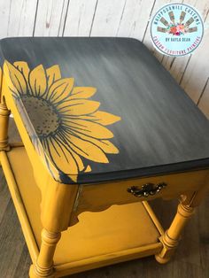 a yellow and black table with a sunflower painted on it