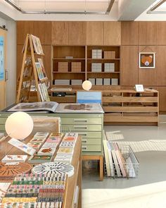 a room filled with lots of books and desks next to each other in front of wooden shelves