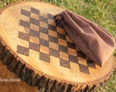 a cloth is sitting on top of a piece of wood that has been carved into a chess board