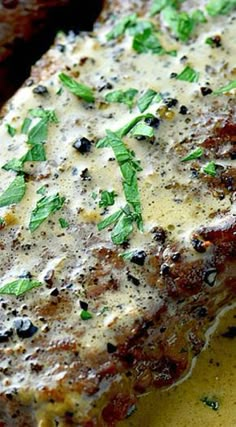 a piece of meat covered in cheese and herbs