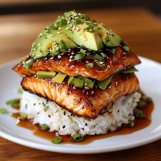 salmon with avocado and sesame seeds on top of rice