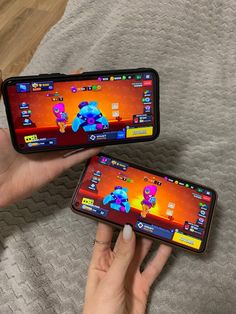 two people holding up their cell phones to show them on the screen and playing games