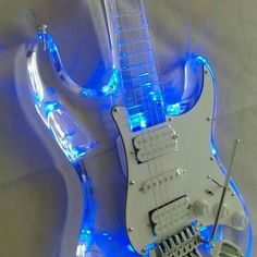 a white electric guitar with blue lights on it