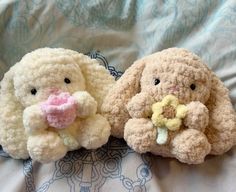 two stuffed animals sitting on top of a bed next to each other, one with a pacifier in its mouth