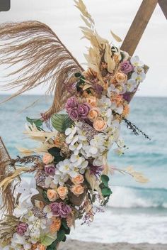 an arrangement of flowers and leaves on the beach