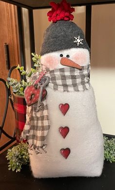 a snowman is sitting next to a potted plant