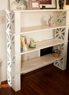 a white shelf with books and pictures on it