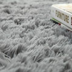 a book sitting on top of a fluffy gray carpet