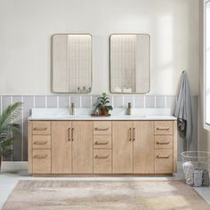 a bathroom with two sinks, mirrors and a rug on the floor in front of it