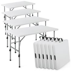 four white folding tables with black handles on each side