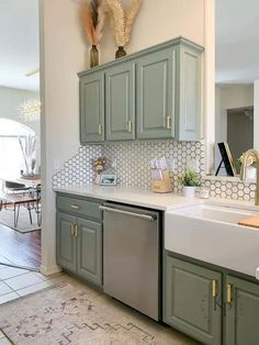 a kitchen with green cabinets and white counter tops