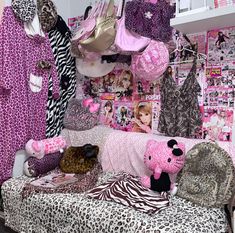 a room filled with lots of pink and zebra print items on the wall next to a bed covered in animal prints