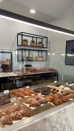 an assortment of breads and pastries on display in a bakery