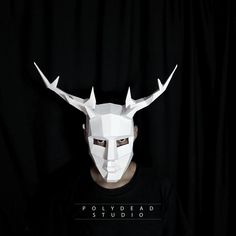 a man wearing a white mask with horns on his head and the words polydead studio in front of him