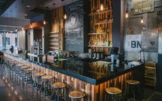 a bar with lots of stools next to it