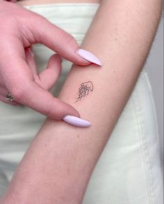 a woman's arm with a small tattoo on it